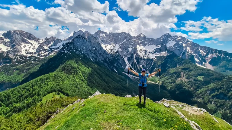 donna felice che allarga le braccia per la gioia sulla cima del goli vrh con vista panoramica sulle montagne kamnik savinja alpi scalate