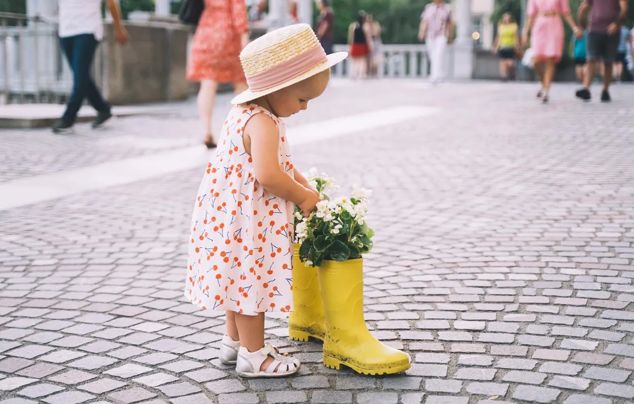 Child having fun looking at rain boots in Ljubljana