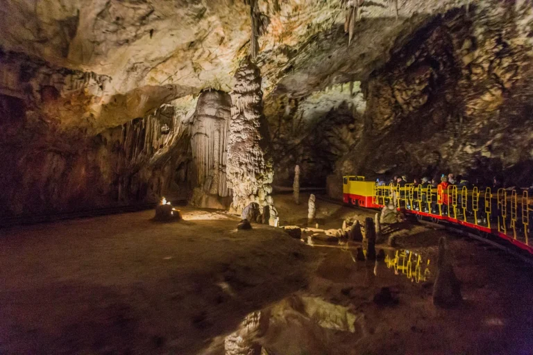 escalada del tren turístico subterráneo de la cueva de postojna